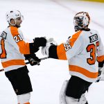Philadelphia Flyers goaltender Martin Jones (35) celebrates with left wing Scott Laughton (21) as time expires in the team's NHL hockey game against the Arizona Coyotes on Saturday, Dec. 11, 2021, in Glendale, Ariz. The Flyers won 5-3. (AP Photo/Ross D. Franklin)