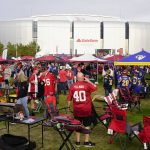 Fans of the Arizona Cardinals and the Los Angeles Rams tailgate in front of State Farm Stadium prior to an NFL football game Monday, Dec. 13, 2021, in Glendale, Ariz. (AP Photo/Darryl Webb)