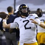 West Virginia quarterback Jarret Doege warms up for the team's Guaranteed Rate Bowl NCAA college football game against Minnesota on Tuesday, Dec. 28, 2021, in Phoenix. (AP Photo/Rick Scuteri)