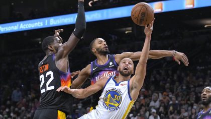 Golden State Warriors guard Stephen Curry (30) shoots between Phoenix Suns center Deandre Ayton (22...