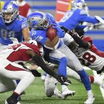 Detroit Lions running back Godwin Igwebuike (35) is stopped by Arizona Cardinals' Jonathan Ward, left, and defensive back Charles Washington (28) during the first half of an NFL football game, Sunday, Dec. 19, 2021, in Detroit. (AP Photo/Lon Horwedel)