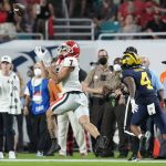Georgia wide receiver Jermaine Burton catches a touchdown pass ahead of Michigan defensive back Vincent Gray during the first half of the Orange Bowl NCAA College Football Playoff semifinal game, Friday, Dec. 31, 2021, in Miami Gardens, Fla. (AP Photo/Rebecca Blackwell)