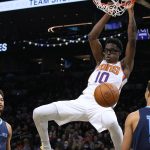 Phoenix Suns forward Jalen Smith (10) dunks over Memphis Grizzlies forwards Kyle Anderson (1) and Brandon Clarke during the first half of an NBA basketball game Monday, Dec. 27, 2021, in Phoenix. (AP Photo/Rick Scuteri)