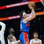 Washington Wizards forward Corey Kispert, middle, drives past Phoenix Suns forward Jae Crowder, left, Suns center Deandre Ayton, second from left, and Suns forward Cameron Johnson, right, during the first half of an NBA basketball game Thursday, Dec. 16, 2021, in Phoenix. (AP Photo/Ross D. Franklin)
