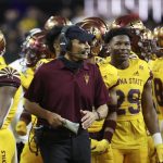 Arizona State head coach Herm Edwards speaks with his players during the first half of the Las Vegas Bowl NCAA college football game against Wisconsin, Thursday, Dec. 30, 2021, in Las Vegas. (AP Photo/L.E. Baskow)
