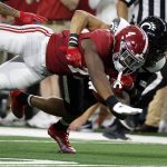 Alabama's Brian Robinson Jr. (4) is tackled by Cincinnati's Bryan Cook during the first half of the Cotton Bowl NCAA College Football Playoff semifinal game, Friday, Dec. 31, 2021, in Arlington, Texas. (AP Photo/Michael Ainsworth)