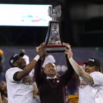 Minnesota defensive back Tyler Nubin, left, coach P.J. Fleck and running back Ky Thomas hold up the trophy after Minnesota defeated West Virginia 18-6 in the Guaranteed Rate Bowl NCAA college football game Tuesday, Dec. 28, 2021, in Phoenix. (AP Photo/Rick Scuteri)