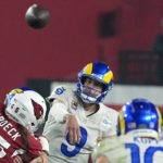 Los Angeles Rams quarterback Matthew Stafford (9) throws a pass to Rams wide receiver Cooper Kupp (10) as Arizona Cardinals linebacker Dennis Gardeck, left, is blocked during the first half of an NFL football game Monday, Dec. 13, 2021, in Glendale, Ariz. (AP Photo/Rick Scuteri)