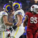 Los Angeles Rams wide receiver Cooper Kupp (10) celebrates his touchdown catch with guard Austin Corbett (63) as Arizona Cardinals defensive tackle Leki Fotu (95) looks away during the second half of an NFL football game Monday, Dec. 13, 2021, in Glendale, Ariz. (AP Photo/Ralph Freso)