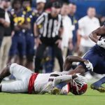 Michigan wide receiver Cornelius Johnson is tackled by Georgia defensive back Derion Kendrick during the second half of the Orange Bowl NCAA College Football Playoff semifinal game, Friday, Dec. 31, 2021, in Miami Gardens, Fla. (AP Photo/Rebecca Blackwell)