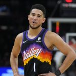 Phoenix Suns guard Devin Booker reacts to a foul called against him during the first half of the team's NBA basketball game against the Golden State Warriors, Saturday, Dec. 25, 2021, in Phoenix. (AP Photo/Rick Scuteri)