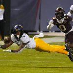 West Virginia wide receiver Winston Wright Jr. (1) tries to make a catch in front of Minnesota defensive back Justin Walley during the first half of the Guaranteed Rate Bowl NCAA college football game Tuesday, Dec. 28, 2021, in Phoenix. (AP Photo/Rick Scuteri)