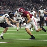 Alabama tight end Cameron Latu (81) scores a touchdown after catching a pass as Cincinnati Ty Van Fossen, left, defends during the second half of the Cotton Bowl NCAA College Football Playoff semifinal game, Friday, Dec. 31, 2021, in Arlington, Texas. (AP Photo/Jeffrey McWhorter)