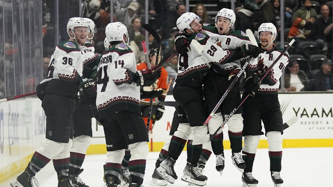 Arizona Coyotes celebrate after right wing Clayton Keller, second from right, scored the winning go...