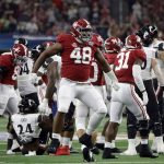 Alabama defensive lineman Phidarian Mathis (48) celebrates after tackling Cincinnati running back Jerome Ford (24) during the first half of the Cotton Bowl NCAA College Football Playoff semifinal game, Friday, Dec. 31, 2021, in Arlington, Texas. (AP Photo/Michael Ainsworth)