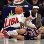 Illinois' Trent Frazier, top, battles for the ball with Arizona's Kerr Kriisa (25) during the first half of an NCAA college basketball game Saturday, Dec. 11, 2021, in Champaign, Ill. (AP Photo/Charles Rex Arbogast)
