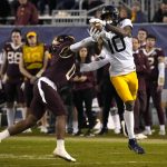 West Virginia wide receiver Sean Ryan (10) tries to catch a pass front of Minnesota defensive back Justin Walley during the second half of the Guaranteed Rate Bowl NCAA college football game Tuesday, Dec. 28, 2021, in Phoenix. Minnesota won 18-6. (AP Photo/Rick Scuteri)
