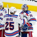 New York Rangers goaltender Keith Kinkaid (71) celebrates a win against the Arizona Coyotes with Rangers defenseman Libor Hajek (25) and Rangers right wing Julien Gauthier (15) after an NHL hockey game Wednesday, Dec. 15, 2021, in Glendale, Ariz. The Rangers won 3-2. (AP Photo/Ross D. Franklin)