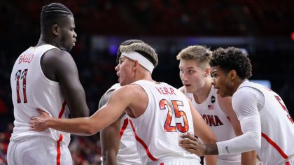 Guard Kerr Kriisa #25 talks to center Oumar Ballo #11 of the Arizona Wildcats in a huddle during th...