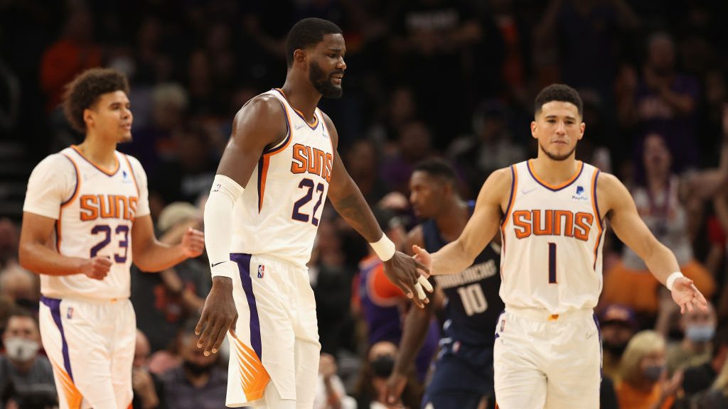 Deandre Ayton #22 of the Phoenix Suns high fives Devin Booker #1 after scoring against the Dallas M...