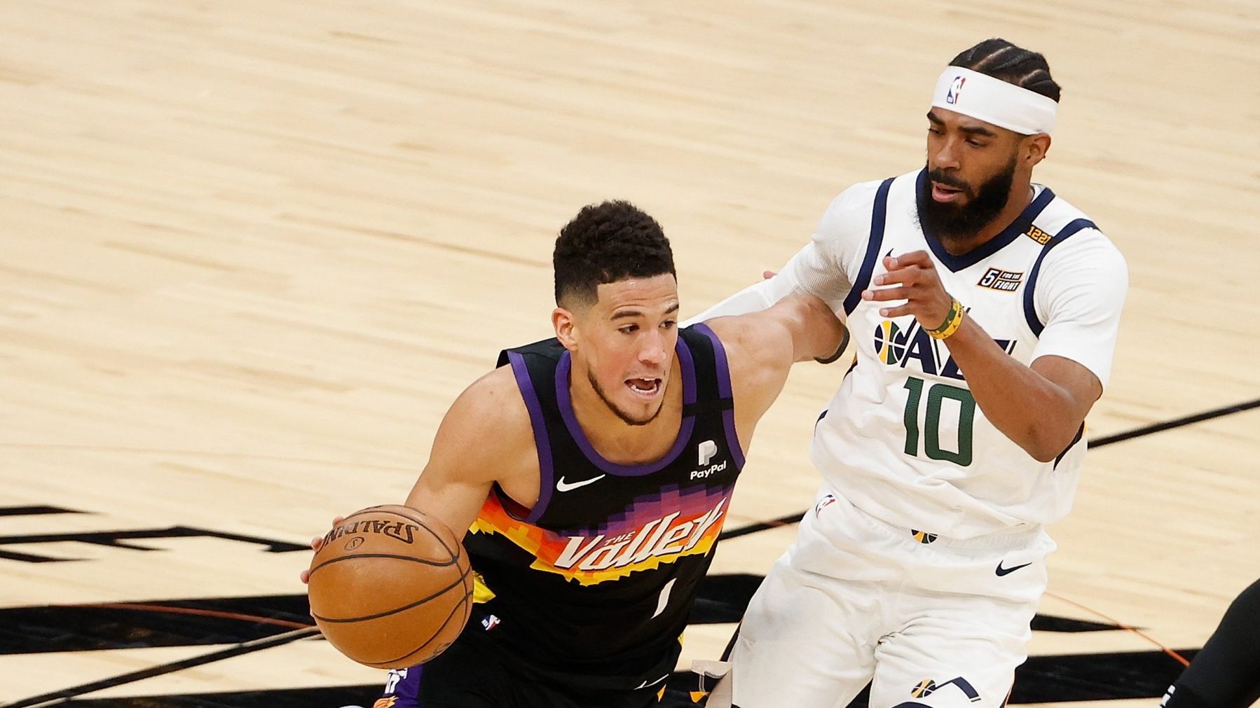 Devin Booker #1 of the Phoenix Suns drives the ball past Mike Conley #10 of the Utah Jazz during th...