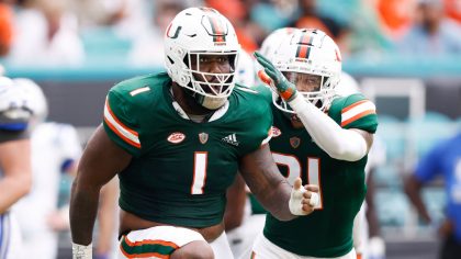 Nesta Jade Silvera #1 and Bubba Bolden #21 of the Miami Hurricanes celebrate a tackle on third down...