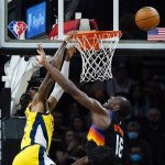 Indiana Pacers forward Oshae Brissett, left, is fouled by Phoenix Suns center Bismack Biyombo, right, as Brissett misses a dunk during the second half of an NBA basketball game Saturday, Jan. 22, 2022, in Phoenix. (AP Photo/Ross D. Franklin)