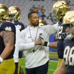 Notre Dame head coach Marcus Freeman greets players prior to the Fiesta Bowl NCAA college football game against Oklahoma State, Saturday, Jan. 1, 2022, in Glendale, Ariz. (AP Photo/Rick Scuteri)