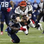 Cincinnati Bengals quarterback Joe Burrow (9) leaps for a first down against Tennessee Titans inside linebacker Jayon Brown (55) during the second half of an NFL divisional round playoff football game, Saturday, Jan. 22, 2022, in Nashville, Tenn. (AP Photo/Mark Zaleski)