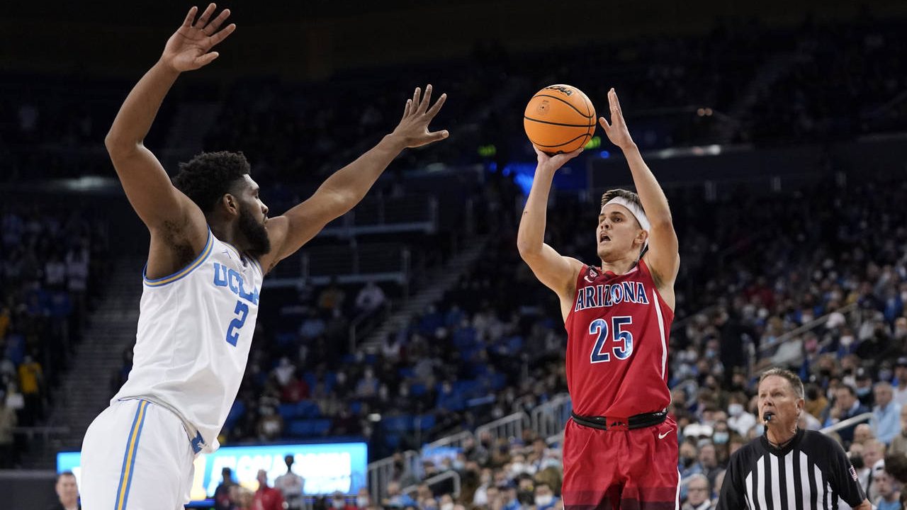 Arizona guard Kerr Kriisa, right, shoots as UCLA forward Cody Riley defends during the first half o...