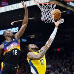 Phoenix Suns center Bismack Biyombo (18) jumps up to block a shot by Indiana Pacers forward Oshae Brissett (12) during the first half of an NBA basketball game Saturday, Jan. 22, 2022, in Phoenix. (AP Photo/Ross D. Franklin)
