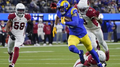 Los Angeles Rams tight end Tyler Higbee, foreground, runs against Arizona Cardinals inside lineback...