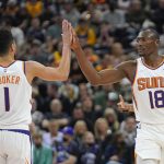 Phoenix Suns' Devin Booker (1) and Bismack Biyombo (18) high-five during the first half during an NBA basketball game against the Utah Jazz Wednesday, Jan. 26, 2022, in Salt Lake City. (AP Photo/Rick Bowmer)