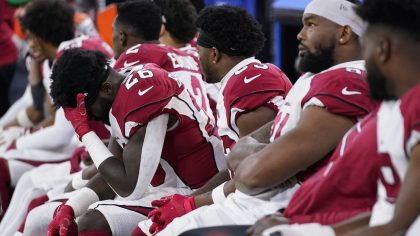 Arizona Cardinals running back Eno Benjamin, left, sits on the bench with teammates during the seco...