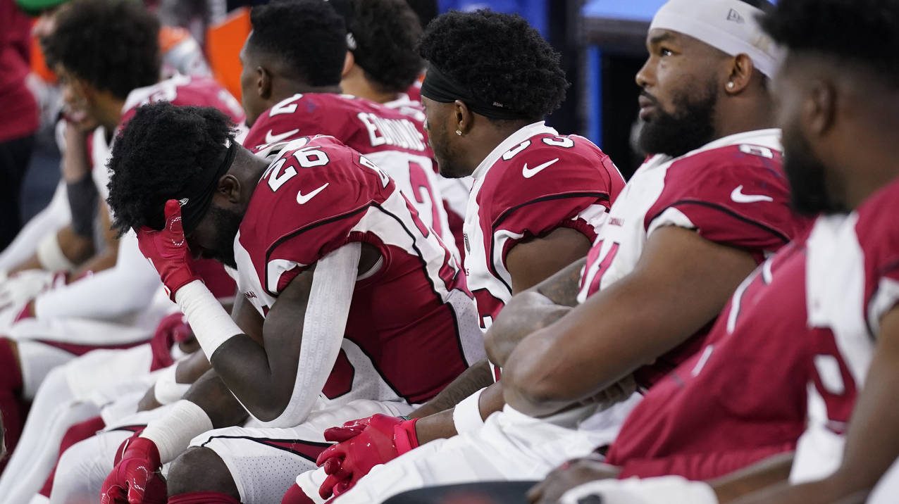 Arizona Cardinals running back Eno Benjamin, left, sits on the bench with teammates during the seco...