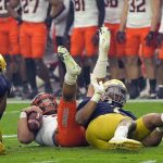 Oklahoma State quarterback Spencer Sanders is sacked by Notre Dame defensive lineman Isaiah Foskey, right, and defensive lineman Justin Ademilola, left, during the first half of the Fiesta Bowl NCAA college football game, Saturday, Jan. 1, 2022, in Glendale, Ariz. (AP Photo/Rick Scuteri)