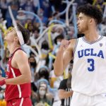 UCLA guard Johnny Juzang, right, celebrates a turnover as Arizona guard Kerr Kriisa looks toward the scoreboard during the second half of an NCAA college basketball game Tuesday, Jan. 25, 2022, in Los Angeles. (AP Photo/Mark J. Terrill)