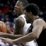 Colorado forward Evan Battey, right, battles for the ball with  Arizona guard Dalen Terry (4) on his drive during the first half of an NCAA college basketball game Thursday, Jan. 13, 2022 in Tucson, Ariz. (Kelly Presnell/Arizona Daily Star via AP)