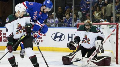 Arizona Coyotes center Riley Nash (20) and New York Rangers left wing Alexis Lafreniere (13) watch ...