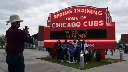 Fans take a photo in front of the Chicago Cubs Spring Training sign before a spring training baseba...
