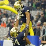 Notre Dame running back Chris Tyree (25) celebrates his touchdown against Oklahoma State with Notre Dame offensive lineman Blake Fisher (54) during the first half of the Fiesta Bowl NCAA college football game, Saturday, Jan. 1, 2022, in Glendale, Ariz. (AP Photo/Rick Scuteri)