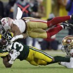 San Francisco 49ers' Fred Warner stops Green Bay Packers' Aaron Jones during the first half of an NFC divisional playoff NFL football game Saturday, Jan. 22, 2022, in Green Bay, Wis. (AP Photo/Matt Ludtke)