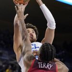 UCLA guard Johnny Juzang, top, shoots as Arizona guard Dalen Terry defends during the second half of an NCAA college basketball game Tuesday, Jan. 25, 2022, in Los Angeles. (AP Photo/Mark J. Terrill)