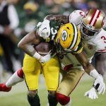 Green Bay Packers' Aaron Jones is stopped by San Francisco 49ers' Jaquiski Tartt during the first half of an NFC divisional playoff NFL football game Saturday, Jan. 22, 2022, in Green Bay, Wis. (AP Photo/Aaron Gash)