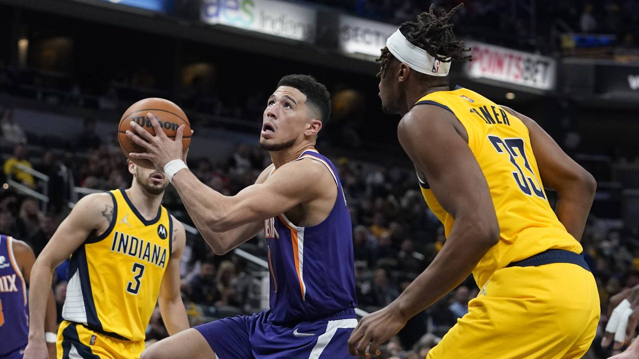 Phoenix Suns' Devin Booker goes to the basket against Indiana Pacers' Myles Turner (33) during the ...