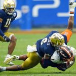Notre Dame cornerback Clarence Lewis (6) tackles Oklahoma State wide receiver Tay Martin (1) during the second half of the Fiesta Bowl NCAA college football game, Saturday, Jan. 1, 2022, in Glendale, Ariz. (AP Photo/Ross D. Franklin)
