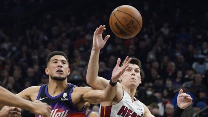 Phoenix Suns' Devin Booker (1) battles for the ball with Miami Heat's Tyler Herro (14) during the f...