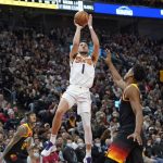 Phoenix Suns guard Devin Booker (1) shoots as Utah Jazz center Hassan Whiteside, right, defends in the second half during an NBA basketball game Wednesday, Jan. 26, 2022, in Salt Lake City. (AP Photo/Rick Bowmer)