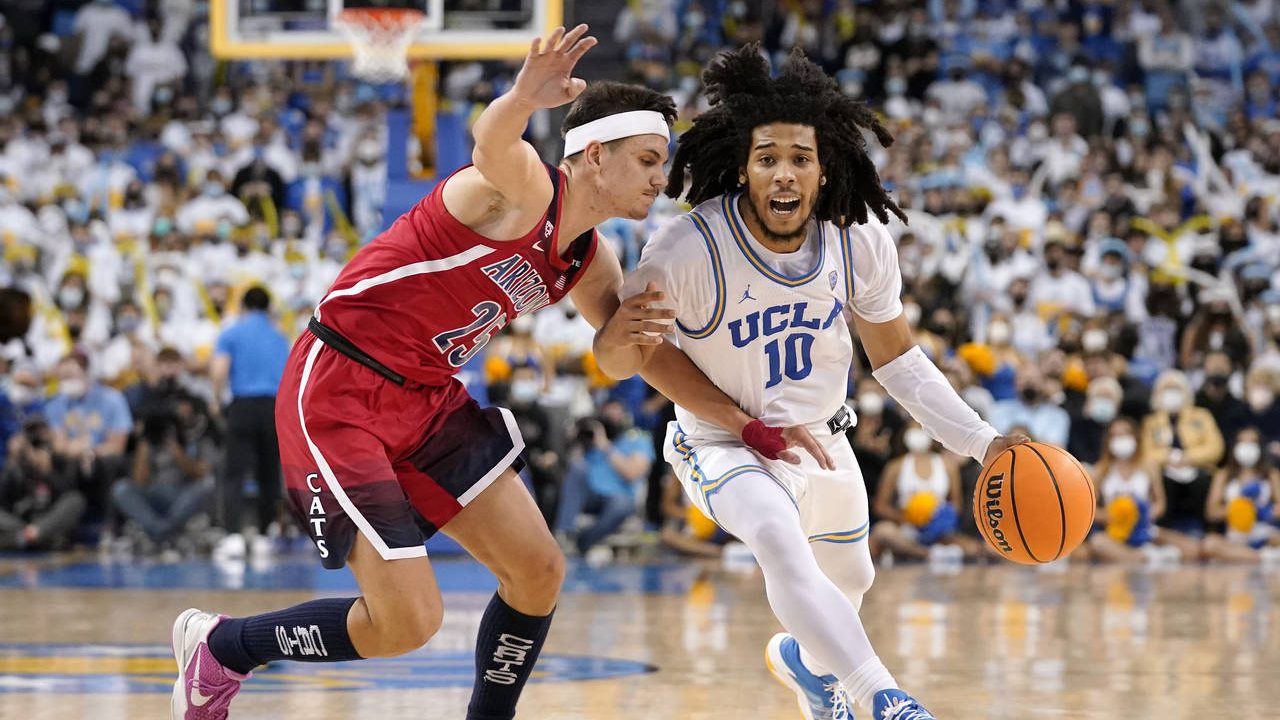 UCLA guard Tyger Campbell, right, drives toward the basket as Arizona guard Kerr Kriisa defends dur...
