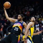 Phoenix Suns forward Mikal Bridges (25) grabs a rebound in front of Indiana Pacers guard Jeremy Lamb, right, during the first half of an NBA basketball game Saturday, Jan. 22, 2022, in Phoenix. (AP Photo/Ross D. Franklin)